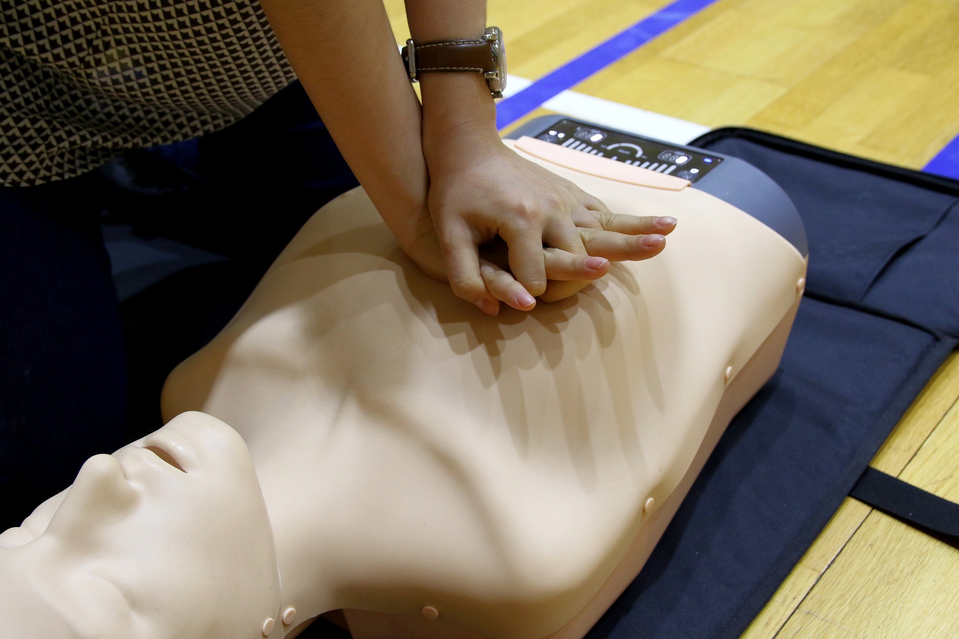 A person performing CPR on a dummy.